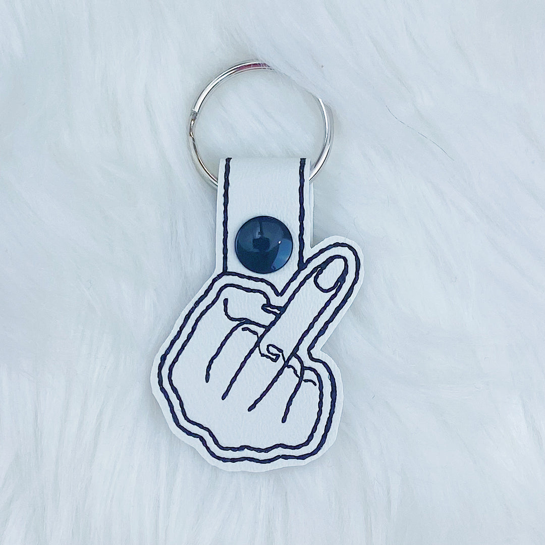 Charm con lengüeta a presión Feltie de dedo medio blanco