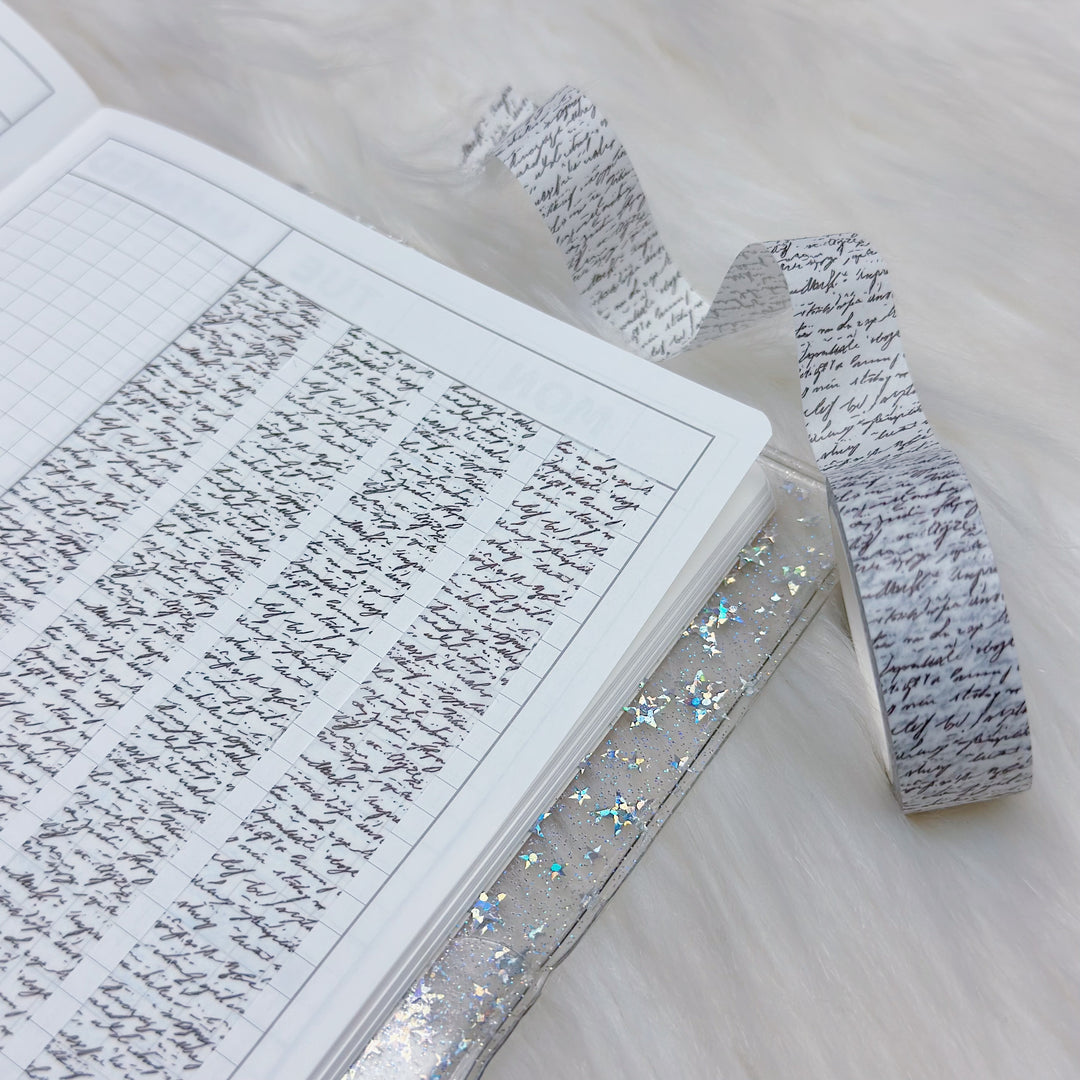Open book with handwritten text and a decorative ribbon on a light background