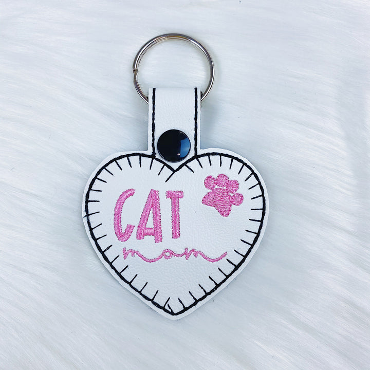 Charm con pestaña a presión de fieltro con forma de corazón de mamá y gato con costuras rosas